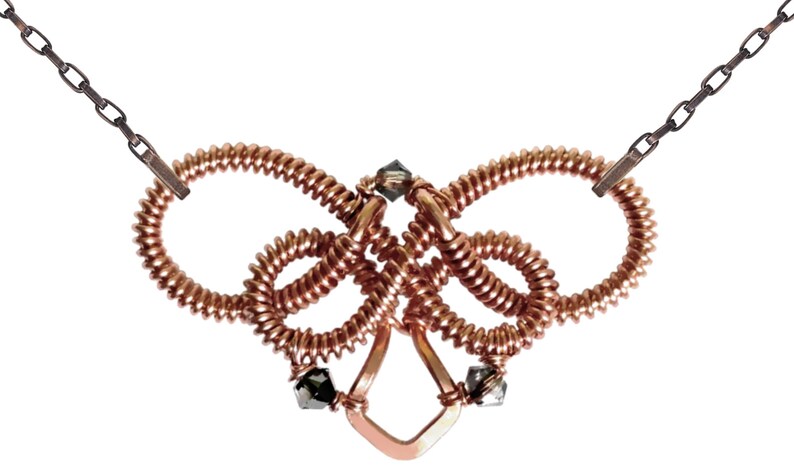 Op de afbeelding: Een koperen draadketting met een geknoopt ontwerp en zwarte kristallen accenten. De ketting is gemaakt van meerdere lussen draad die met elkaar zijn verweven om een uniek en ingewikkeld ontwerp te cre&euml;ren.