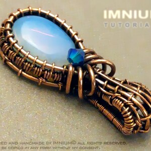 Op de afbeelding: Een hanger van gewikkeld koperdraad met een lichtblauwe opaal en een klein blauw kristal. De hanger is ontworpen en met de hand gemaakt door Imnliimo.