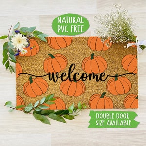 Può includere: Un tappetino di benvenuto con un motivo a zucca e la parola "welcome" in scrittura corsiva nera. Il tappetino è realizzato in fibra di cocco naturale ed è privo di PVC. Il tappetino è disponibile in una dimensione per doppia porta.