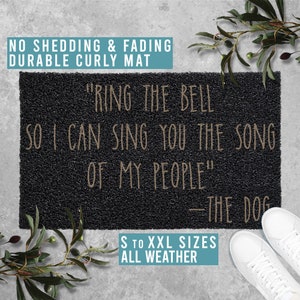 May include: Black doormat with the text "Ring the bell so I can sing you the song of my people" - The dog.  The doormat is made of curly fibers and is available in sizes S to XXL.  The doormat is all weather.