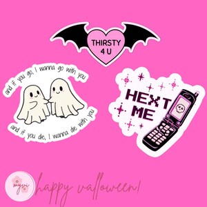 May include: A collection of Halloween-themed stickers on a pink background. The stickers include a bat-winged heart with "THIRSTY 4 U", two ghost figures with text, and a pixelated phone with "HEXT ME". The image also includes the text "happy walloween!"