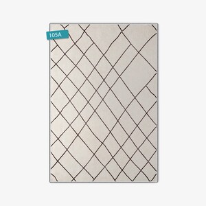 May include: A white rug with a black diamond pattern. The rug has a label that says "105A".