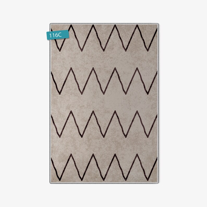 May include: A beige rug with a black chevron pattern. The rug has a subtle texture and a modern design.