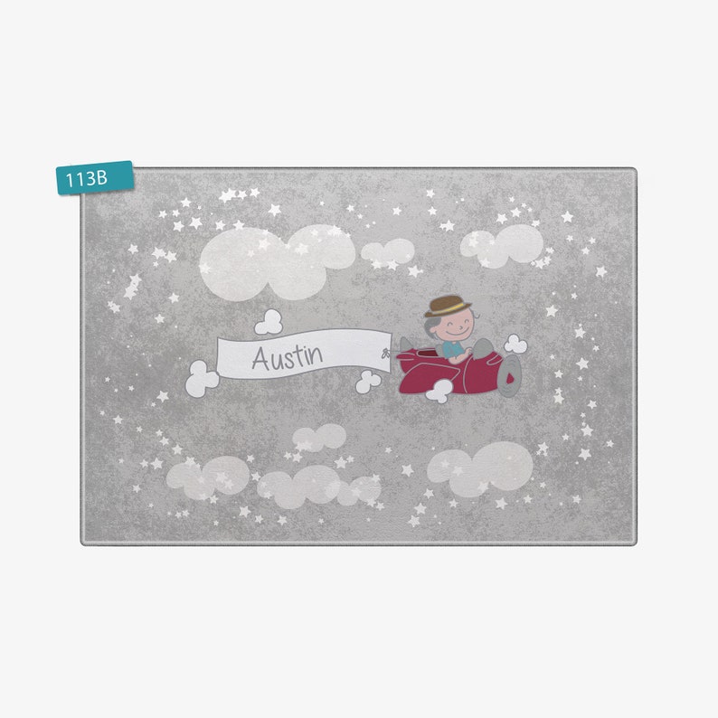 May include: A gray and white personalized children's rug with a cartoon of a boy flying a red airplane with a banner that says "Austin" in white letters. The rug has a white cloud and star pattern.