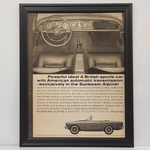 May include: Framed black and white advertisement for the Sunbeam Alpine sports car. The image shows the car's interior, including the steering wheel, seats, and gear shift. Text highlights the car's automatic transmission.