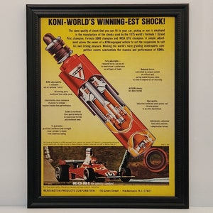 May include: A vintage advertisement for KONI shock absorbers, featuring a cutaway illustration of a red shock absorber with detailed descriptions of its features. The ad also showcases a red race car speeding on a track, highlighting the brand's association with high-performance vehicles.