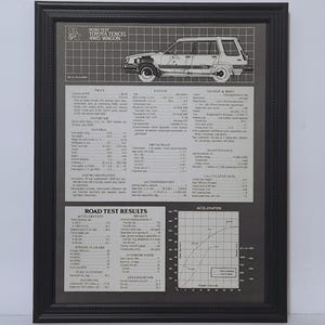 May include: A framed black and white technical print titled Road Test Toyota Tercel 4WD Wagon. The document features a line drawing of the vehicle, detailed mechanical specifications, performance data, and an acceleration graph on a grid background.