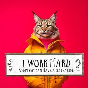 May include: A wooden sign with the text "I work hard so my cat can have a better life." The sign is held by a lynx wearing a yellow jacket and a pink turtleneck.