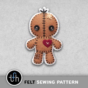 May include: A brown felt doll with button eyes, a red heart, and stitched details. The doll has a white outline and a small patch on its head. The text "FELT SEWING PATTERN" is at the bottom.