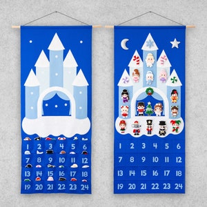 Könnte beinhalten: Blauer Filz-Adventskalender in Form eines Schlosses mit 24 nummerierten Taschen und verschiedenen Filzfiguren. Der Kalender hängt an einer Wand mit einer Holzleiste.