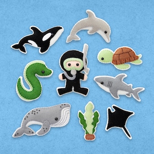 May include: Felt appliqué set featuring a scuba diver, a whale, a shark, a dolphin, a sea turtle, a seahorse, a stingray, and seaweed. The set is made of felt and is perfect for a child's playroom or bedroom.