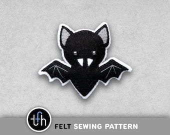 May include: A black felt bat with white trim and silver accents. The bat has outstretched wings and a smiling face. The image includes the text "FELT SEWING PATTERN" and a logo.