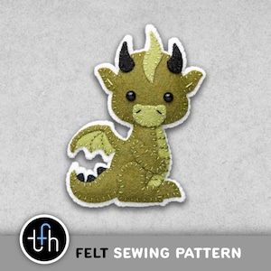 May include: A felt dragon sewing pattern in shades of green, with black horns and wings. The dragon has a white outline and is sitting. The text "FELT SEWING PATTERN" is below the dragon.