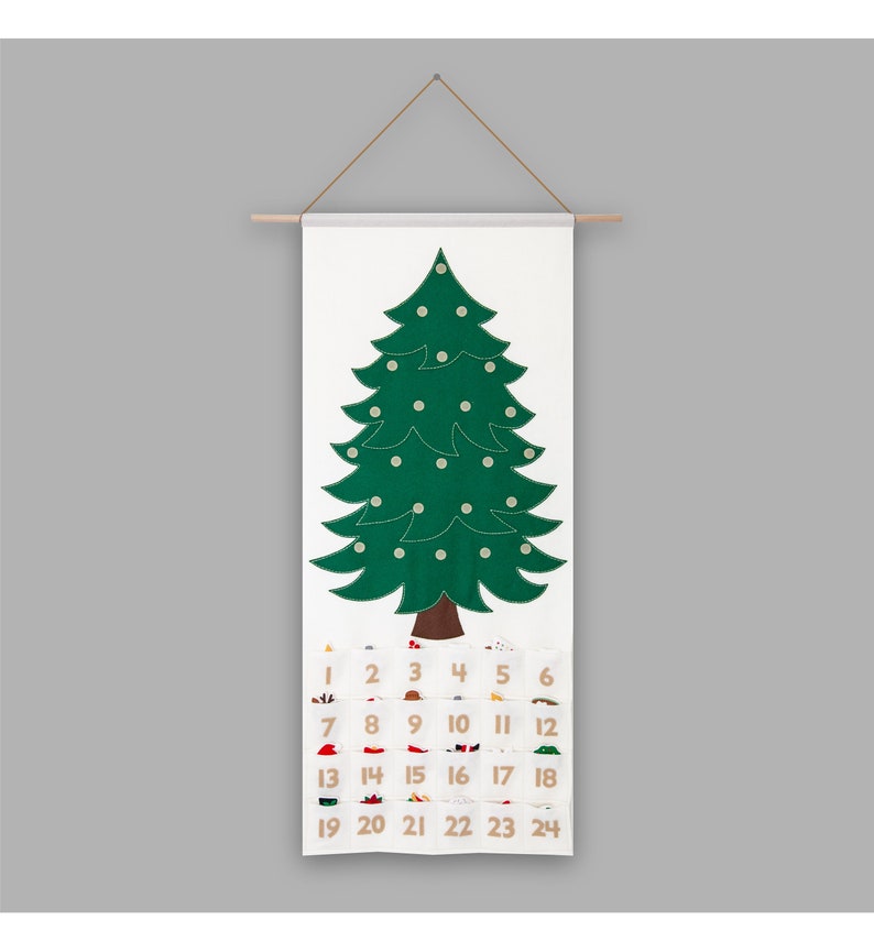 May include: A white felt Christmas tree advent calendar with 24 numbered pockets. The tree is green with white felt ornaments. The numbers are in brown felt.