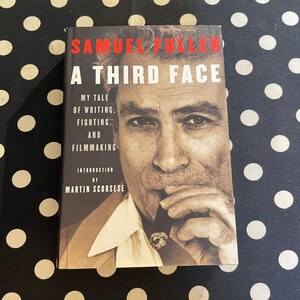 May include: A book titled "A Third Face" by Samuel Fuller, with the subtitle "My Tale of Writing, Fighting, and Filmmaking." The cover features a black and white portrait of a man holding a cigar. The introduction is by Martin Scorsese.