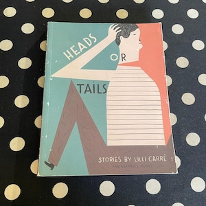 May include: A vintage book titled "Heads or Tails" with a stylized illustration of a person. The cover features a teal and coral color scheme with the text "Stories by Lilli Carré" and the Fantagraphics Books logo.