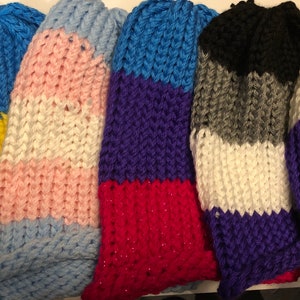 May include: Five knitted hats in different colors and patterns. The hats are striped with colors including yellow, blue, pink, white, gray, black, purple, and red.