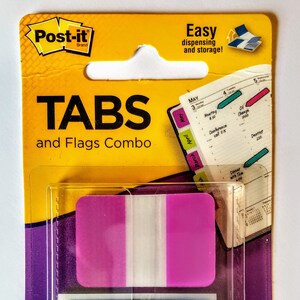 May include: A package of Post-it Tabs and Flags Combo. The package includes pink, blue, and green tabs and flags. The package dimensions are 47 inches by 1.7 inches. The package has the words "TABS and Flags Combo" printed on it.