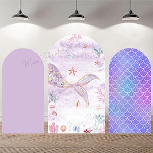 May include: Three arched panels for a mermaid-themed party. The central panel shows a mermaid's tail against a watercolour background, with starfish and coral. The right panel has a scale pattern. The left panel is solid lavender. The text "Miss Zebra Studios" is visible.
