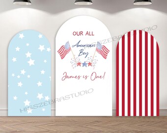 May include: Three arched panels with patriotic designs. One panel is light blue with white stars. The center panel reads "Our All American Boy, James is One!" with American flags. The third panel has red and white stripes.