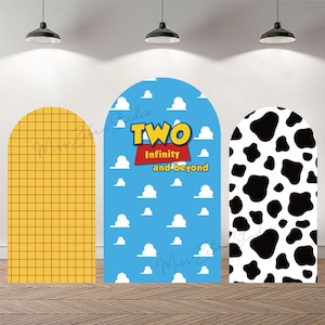 Op de afbeelding: Drie boogvormige achtergrondpanelen. Eén paneel is geel met een rasterpatroon, een ander is blauw met witte wolken en de tekst "TWO Infinity and beyond", en de derde is wit met zwarte koeienvlekken.