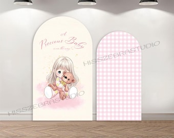 May include: Two arched backdrop panels. The left panel is cream-colored with a watercolor illustration of a child holding a brown teddy bear and the text A Precious Baby is on the way. The right panel features a light pink and white gingham pattern.