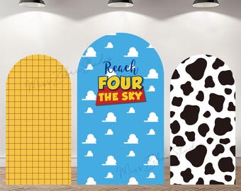 May include: Three arched backdrop covers featuring distinct patterns: a yellow grid, a blue sky with white clouds and the text Reach FOUR THE SKY, and a black and white cow print. These fabric panels are designed for event displays and photography.