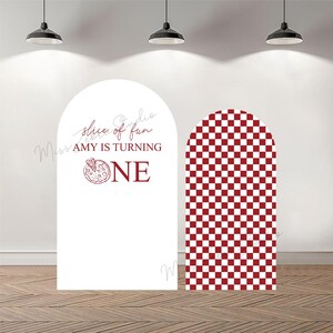 May include: Two arched backdrop panels for events. The left panel is white with red text reading slice of fun AMY IS TURNING ONE and a pizza graphic. The right panel features a red and white checkered pattern. Both panels have a rounded top edge.