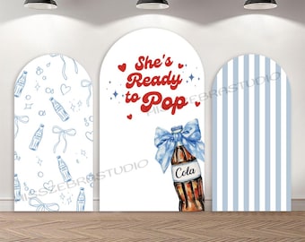 May include: A three-panel backdrop with a baby shower theme. The center panel features a cola bottle with a blue bow and the text "She's Ready to Pop." The left panel has a blue bottle pattern, and the right panel has blue stripes.