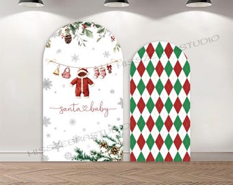 May include: Two arched Christmas backdrops. One features a Santa baby design with a red onesie, snowflakes, and the text "santa baby." The other has a red and green argyle pattern.