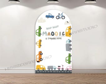 May include: A white arch-shaped backdrop with colorful cartoon vehicles and the text "Beep Beep! Maddie is turning four." The design includes cars, a bicycle, and clouds, suitable for a child's birthday party.