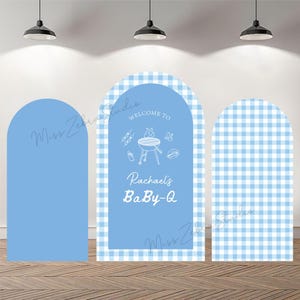 May include: Three arched backdrop covers in light blue. The left and right panels feature a light blue and white gingham pattern. The center panel is solid light blue with white line art of a grill, baby bottle, and pacifier, plus the text "WELCOME TO Rachael's BaBy-Q".