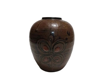 May include: A brown ceramic vase with a stylized floral design in black and brown glaze.