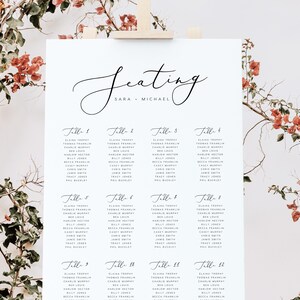 May include: A wedding seating chart with the names of guests listed under each table number. The chart is printed on white paper and has a simple, elegant design. The text "Seating" is written in cursive at the top of the chart, followed by "Sara & Michael".