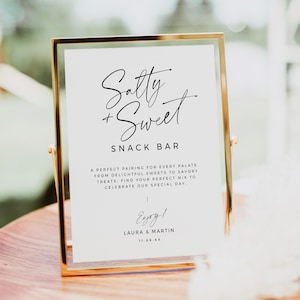 May include: A white sign with a gold frame, reading "Salty + Sweet Snack Bar". The sign also includes the text "A perfect pairing for every palate. From delightful sweets to savory treats. Find your perfect mix to celebrate our special day. Enjoy! Laura & Martin 11.09.XX"