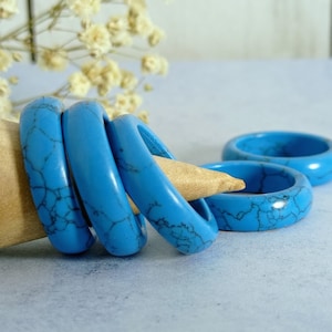Puede incluir: Cuatro anillos turquesa hechos de piedra natural con un patrón de mármol. Los anillos están apilados uno encima del otro.
