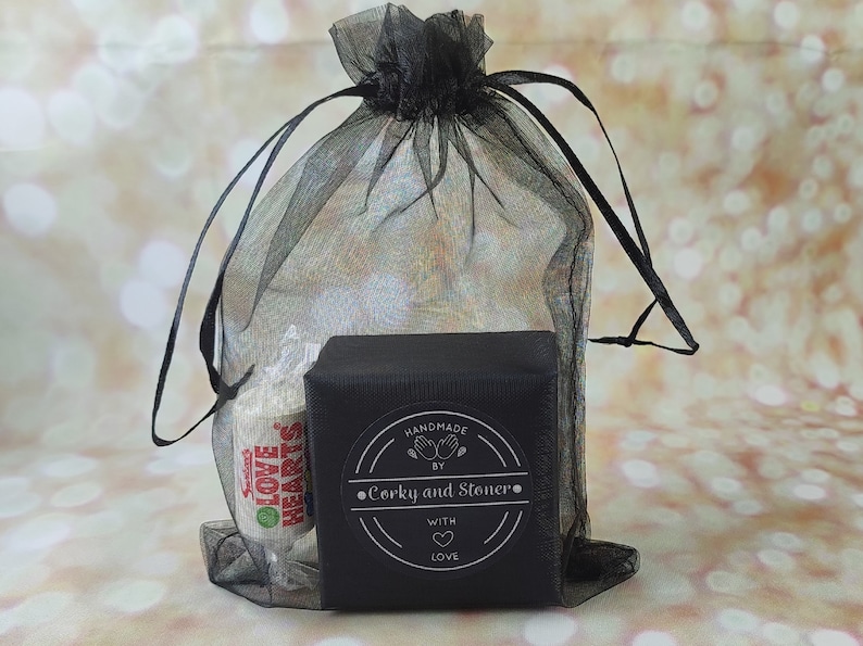 Pode incluir: Uma sacola de presente preta com fecho de cord&atilde;o, contendo uma pequena caixa preta com um r&oacute;tulo branco que diz "Handmade by Corky and Stoner with love".
