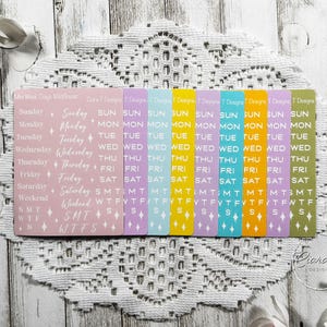 Può includere: Una collezione di adesivi per planner con etichette dei giorni della settimana. Gli adesivi sono in vari colori pastello, tra cui rosa, viola, blu, giallo e verde. Il testo "Ciara Designs" è visibile in basso a destra.