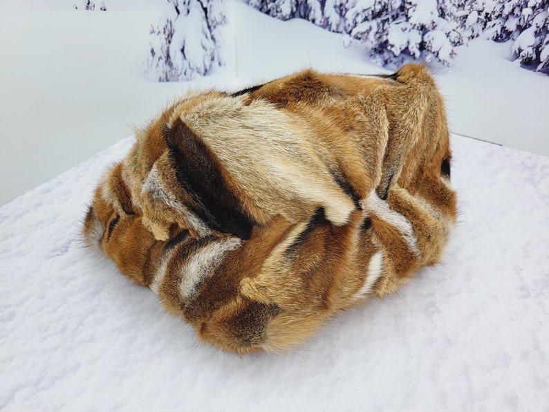 May include: A brown, black, and white fur throw pillow with a soft, fluffy texture.