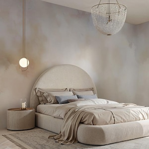 Può includere: Interno di una camera da letto con un letto grande con testiera arrotondata. Il letto è coperto da biancheria da letto dai toni neutri. Un comodino con una candela è accanto al letto e una moderna lampada pende dal soffitto.