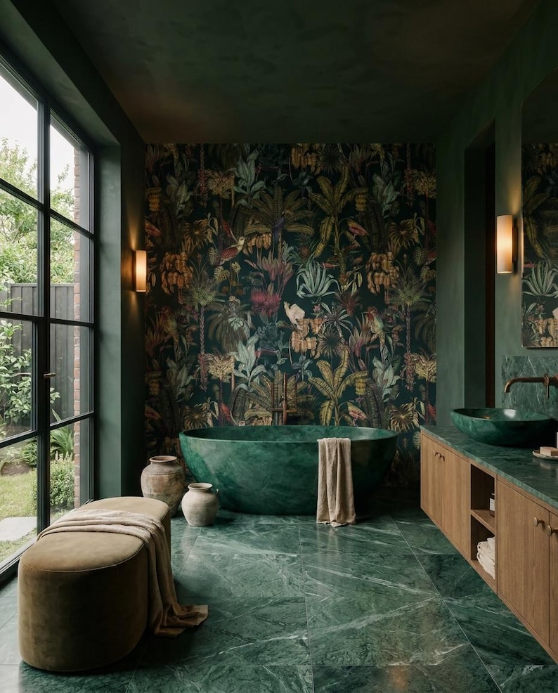 May include: A bathroom featuring a deep green oval soaking tub, a green marble floor, and a vanity with a green marble countertop. The walls are painted dark green, with one wall covered in a dark botanical wallpaper. A beige bench sits nearby.