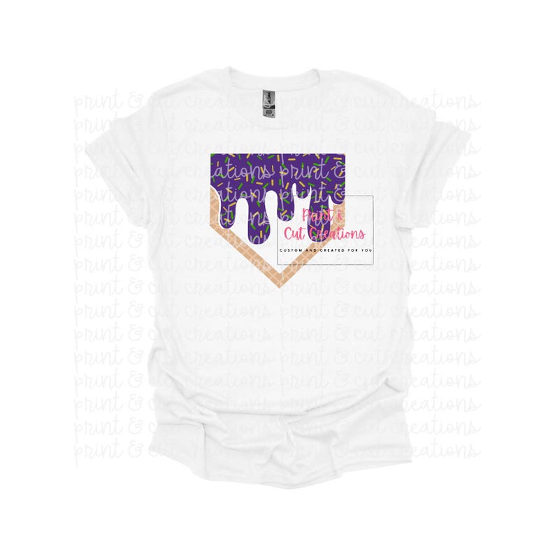 Op de afbeelding: Wit T-shirt met een baseballvormige afbeelding in paars en goud. De afbeelding is een paars, druppelend, gesmolten ontwerp met gouden sprinkels. De tekst "Purple Cut Creations" staat op de afbeelding.