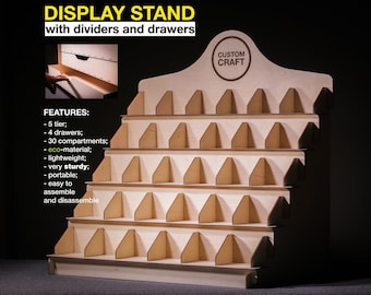 May include: Wooden display stand with five tiers, four drawers, and thirty compartments. The stand is made from eco-friendly material and is lightweight, sturdy, and portable. It is easy to assemble and disassemble. The stand has a sign that says "CUSTOM CRAFT".