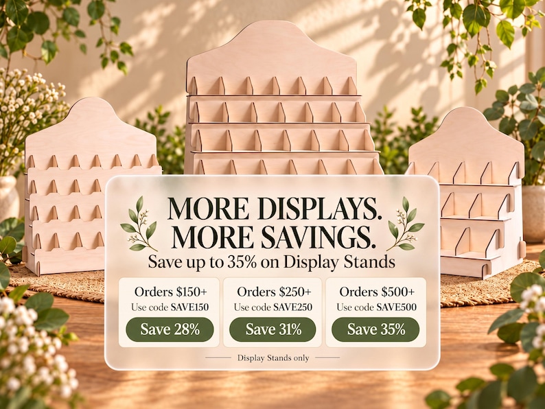 May include: Three light-colored wooden tiered display stands with multiple slots for organizing items. A translucent overlay features the text: MORE DISPLAYS. MORE SAVINGS. Save up to 35% on Display Stands. Orders $150+ Use code SAVE150 Save 28%.
