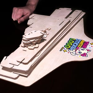 Countertop wooden sticker display stand shown packed flat with header panel.