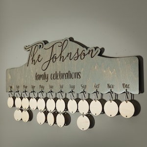 May include: A wooden wall calendar with the text "The Johnson family celebrations" and a space for each month of the year. The calendar has 12 small wooden circles for each month.