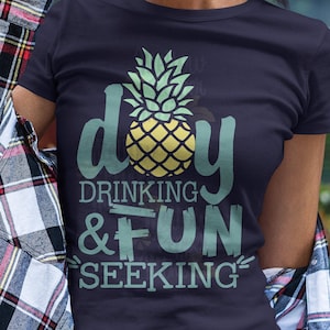 May include: A navy blue t-shirt with a pineapple graphic and the text "day drinking & fun seeking".