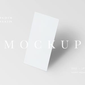 May include: A white rectangular mockup card, slightly angled, with the word "MOCKUP" in the center. Dimensions are 3.9 x 8.3 inches and 9.9 x 21 cm. The image also includes "PSD - JPG" and "smart object" text.