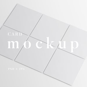 Peut inclure: Maquette de six cartes carrées blanches disposées sur une surface blanche. Le mot « CARD » est au-dessus du mot « mockup » en police serif. En dessous des cartes, le texte « PSD + JPG » est visible.