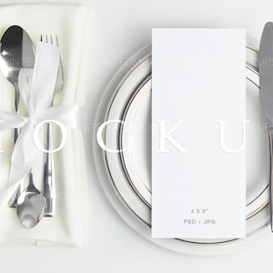 Puede incluir: Una servilleta blanca con un tenedor, una cuchara y un cuchillo de plata atados con una cinta blanca. Una tarjeta blanca con el texto "4 x 9" y "PSD + JPG" está en un plato blanco con un borde dorado.